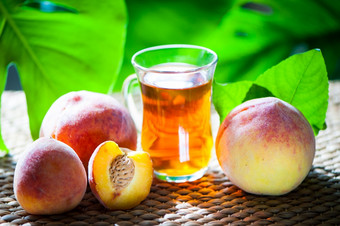 水果茶使从桃子有机茶新鲜的桃子水果整个和一半自然热带背景