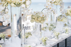 海滩婚礼聚会地点为晚餐接待设置装饰与花花