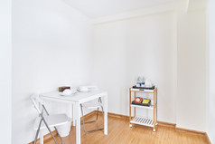 小白色表格与折叠椅子为早餐晚餐厨房角落里的简单的白色清洁房间现代生活与木地板上