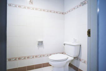 标准设施老通用的厕所。。。厕所房间小酒店公寓与冲洗厕所。。。与简单的陶瓷瓷砖模式装饰