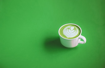 绿色茶概念热火柴绿色茶牛奶奶油与艺术前与白色杯绿色背景为横幅设计与复制空间视图从以上