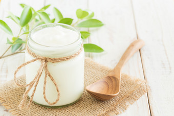 <strong>酸奶</strong>玻璃瓶白色木表格健康的食物概念