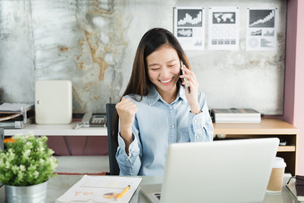 新一代业务女人使用智能手机亚洲女人是幸福的工作的办公室工作成功的概念