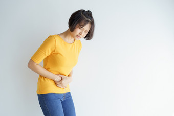 年轻的亚洲<strong>女人</strong>有痛苦的胃痛白色backgroundchronic胃炎<strong>腹部</strong>腹胀概念