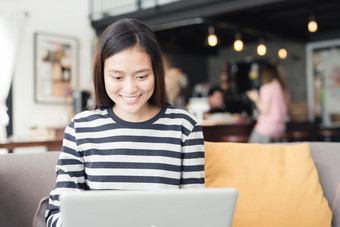新一代业务女人工作与笔记本亚洲女是微笑工作的咖啡商店