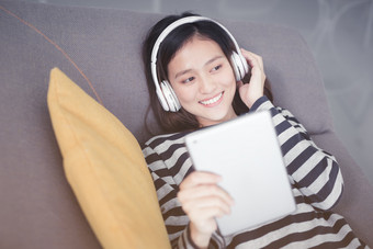 亚洲女人休息听音乐沙发与耳机