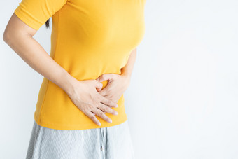 <strong>年轻</strong>的亚洲女人有痛苦的胃痛白色backgroundchronic胃炎腹部腹胀概念
