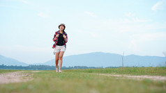 亚洲年轻的女人旅游背包走旅行的自然森林女人旅游走的自然背景山视图