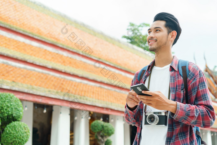 英俊的亚洲男人。旅游走和看聪明的电话什么suthat提普拉拉姆ratchaworawihan曼谷泰国只有旅行和背包客概念