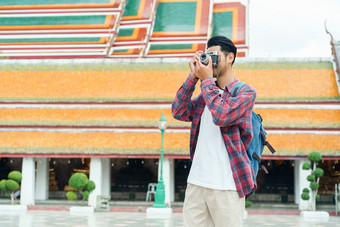 亚洲男人。旅游走采取照片与电影相机什么suthat提普拉拉姆ratchaworawihan曼谷泰国只有旅行和背包客概念