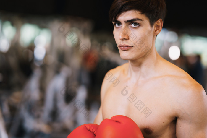 肖像高加索人运动员站而穿拳击手套颜色红色的模糊背景的健身房健身拳击营