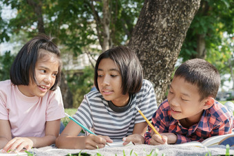 亚洲集团小学学校孩子们写笔记本与铅笔和学习在一起的夏天公园的早....的学生来了研究场旅行和活动学会了户外