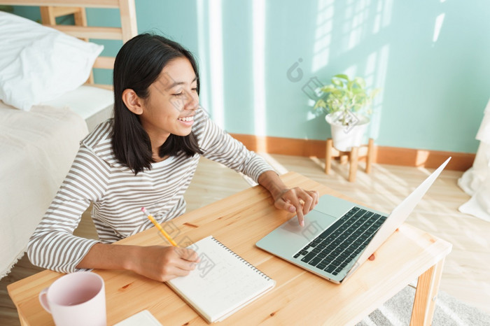 亚洲女孩学习在线通过的互联网导师移动PC电脑亚洲孩子研究而坐着室内首页早....概念在线学习首页