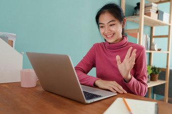 快乐亚洲学生挥舞着问候在线导师移动PC电脑首页亚洲女人穿长袖子粉红色的概念在线学习首页