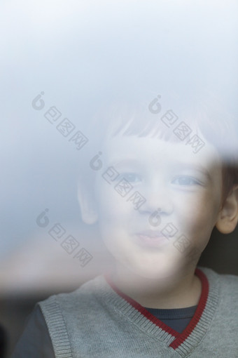 小男孩看的相机后面的玻璃建筑看到从成人工作肖像男孩与微笑小男孩
