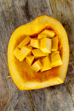 划分成广场块成熟的橙色南瓜的厨房表格烹饪食物从生蔬菜划分橙色南瓜