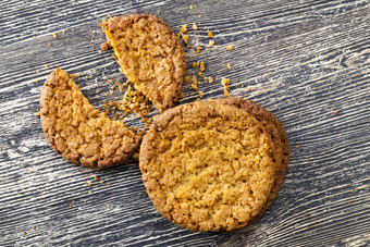 最亲密的燕麦片饼干木表格特写镜头自制的糕点使从燕麦片和小麦面粉破碎的饼干与面包屑的表格破碎的饼干与面包屑的表格