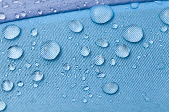 五彩缤纷的蓝色的紫色的雨与水滴后的最后的雨特写镜头在户外的材料透气伞