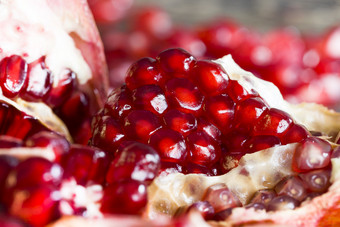 减少红色的成熟的石榴破碎的成块和片特写镜头多汁的健康的浆果包含大量铁减少红色的成熟的石榴