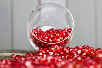 石榴谷物成熟的红色的石榴表格和透明的玻璃杯特写镜头石榴谷物