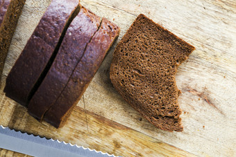 <strong>切片</strong>黑色的黑麦面包面包特写镜头的表格一个位咬黑暗黑麦面包<strong>切片</strong>