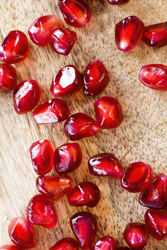 分散红色的成熟的石榴种子水滴木切割董事会后剥水果分散红色的成熟的石榴种子