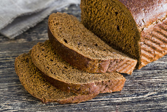 新鲜烤黑色的黑麦面包香温暖的面包是减少成块首页工业生产新鲜烤黑色的黑麦面包