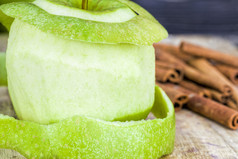 去皮绿色苹果谎言沿着与整个味肉桂黑色的木表格特写镜头自然水果去皮绿色苹果