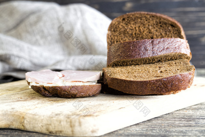 切片香肠说谎切片黑色的黑麦面包特写镜头的厨房切片香肠