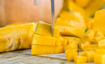 切片和丁橙色南瓜的厨房表格特写镜头生蔬菜之前烹饪切片和丁橙色南瓜