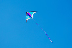 三角形风筝飞行阳光明媚的一天蓝色的天空三角形风筝飞行阳光明媚的一天