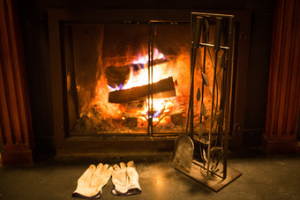 燃烧舒适的壁炉炉与工具和手套空燃烧舒适的壁炉炉与工具和手套