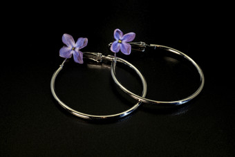 <strong>才华</strong>横溢的轮薄金属耳环和淡紫色花黑色的背景