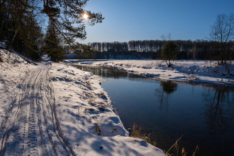 明亮的冬天太阳和小河的雪海岸和蓝色的<strong>万里</strong>无云的天空