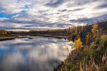 秋天<strong>水景</strong>观与反射的河多云的天空和黄色的树的海岸俄罗斯