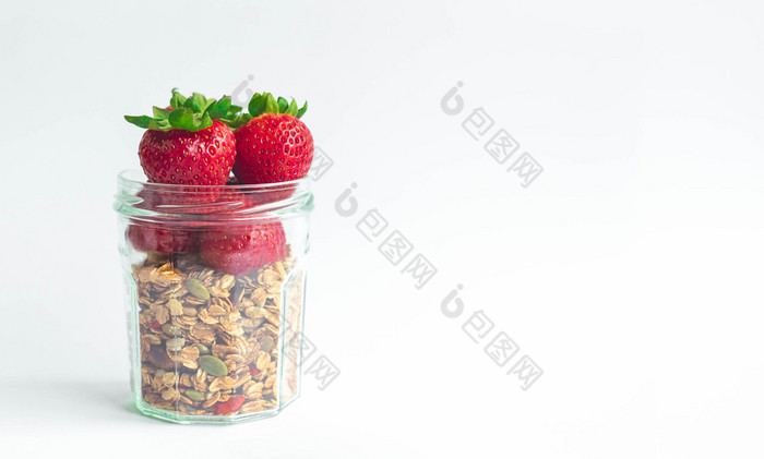 新鲜的草莓与绿色离开头前健康的牛奶什锦早餐格兰诺拉麦片清晰的玻璃瓶白色背景与复制空间为横幅