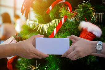 手持有<strong>礼物盒子</strong>快乐圣诞节文本圣诞节树概念背景给<strong>礼物盒子</strong>和取