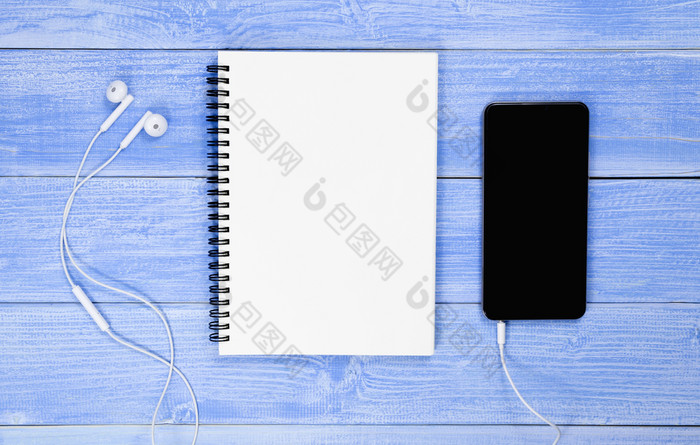 前视图的桌子上与蓝色的笔记本电话和耳机的桌子上为设计使用请注意笔记本与复制空间