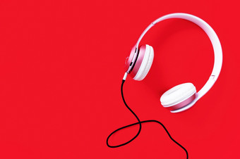 粉红色的耳机和黑色的电缆柔和的颜色红色的背景音乐概念空白复制空间