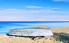 倒金属船桑迪海滩对美丽的平静海景下蓝色的天空夏天早....自然背景与复制空间共和国卡累利阿共和国俄罗斯