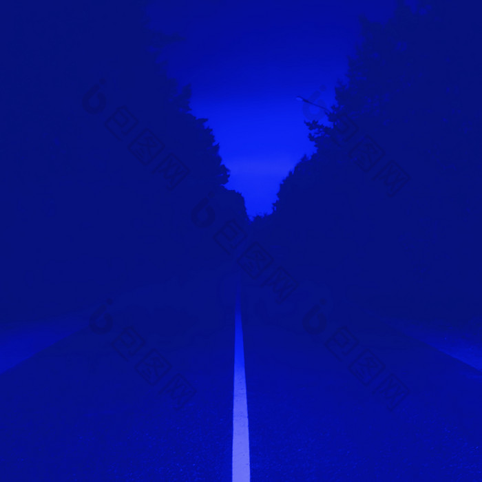 黑暗蓝色的晚上模糊背景森林沥青路与白色分行直接消失成的距离广场背景与空间为复制黑暗蓝色的背景与消失路