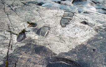 奥涅加岩画的足迹特写镜头史前岩石雕刻的花岗岩海岸共和国卡累利阿共和国俄罗斯自然石头纹理背景岩画的花岗岩海岸