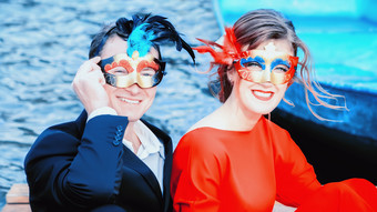 红色的和蓝色的肖像快乐年轻的夫妇化妆<strong>舞会面具</strong>优雅穿着男人。和女人笑对的湖焦点前景快乐男人。和女人化妆<strong>舞会面具</strong>