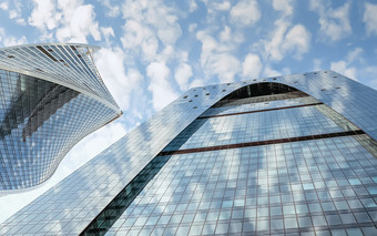 上衣蓝色的办公室建筑与云反射的玻璃墙底视图片段蓝色的玻璃摩天大楼