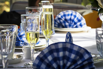 眼镜香槟节日装饰表格与白色和蓝色的餐巾散焦眼镜香槟的表格