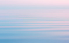 反射的粉红色的日落的流动水表面与白色阴霾摘要海景背景柔和的甜蜜的颜色与运动模糊过滤器空间为复制和设计