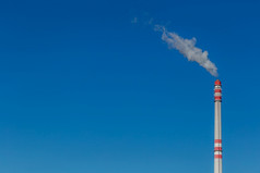 工业烟囱风脏烟从红色的和白色工厂烟囱蓝色的天空长曝光空间为文本