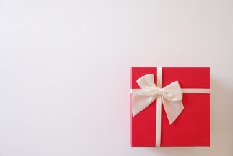 特写镜头红色的礼物盒子与白色丝带白色背景