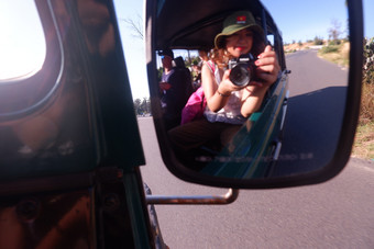 模糊图片女采取自拍反射车一边镜子在旅行