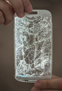 手持有破碎的屏幕智能电话背光真实的光